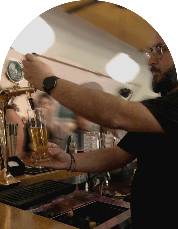 A bartender pours Greek beer from the tap